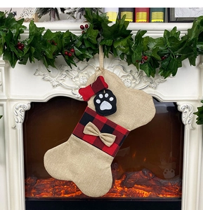Gros plan d'une chaussette de Noël pour animaux en forme d'os sur une cheminée rustique