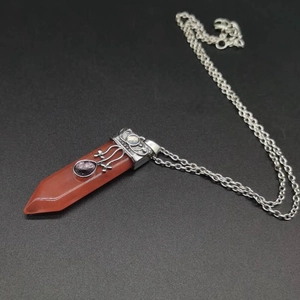 Macro view of carnelian hexagonal point necklace with vintage silver floral engraving