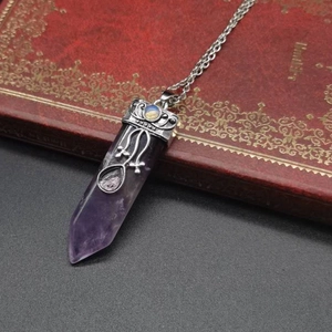 Detailed view of amethyst hexagonal pendant with vintage silver engraving on a book