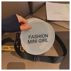 Macro view of clear circular PVC crossbody bag with Fashion Mini Girl logo and yellow strap