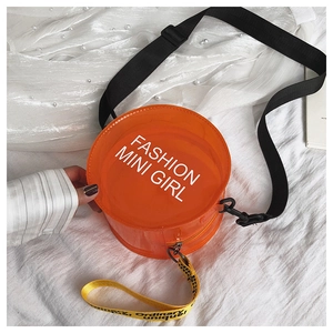 Detail of orange transparent PVC cylinder bag with Fashion Mini Girl text and woven strap