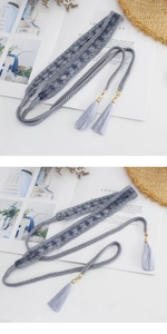 Detailed close-up of a woven gray waist rope with lace flowers and tassel pendant