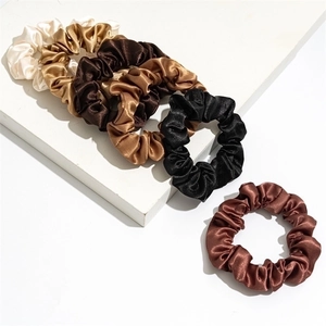 Detail view of multi-colored satin scrunchies set with glossy silk-like texture and high elasticity