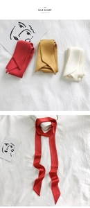 Detailed view of red, gold, and white skinny silk scarves for bags and hair accessories