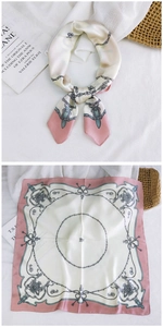 Detail of a vintage pink silk square scarf with heraldic crest and chain patterns