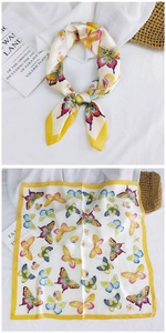 Detail of silk square scarf featuring vibrant butterfly prints and yellow border accents