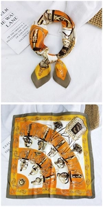 Detail of square silk scarf with vintage sword print in orange and yellow satin