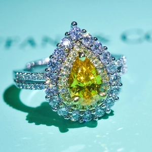 Close-up of luxury pear-cut yellow gemstone ring with double halo diamond setting