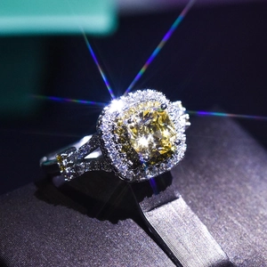 Macro shot of cushion-cut yellow moissanite ring with halo setting on a jewelry box