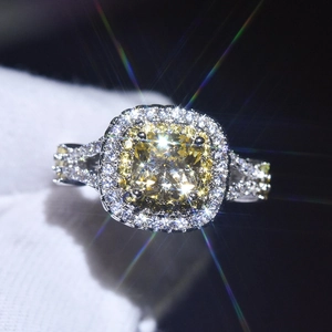 Macro shot of square yellow gemstone ring with diamond halo on gloved finger