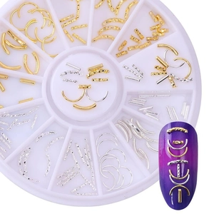 Macro shot of gold and silver metal nail art charms in a white circular divider box
