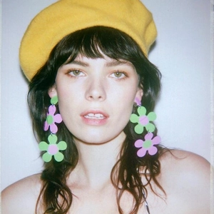 Chic pink and green double-layer acrylic flower earrings worn by a model in a beret