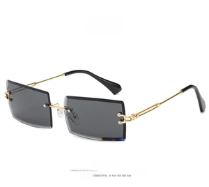 Detail of square rimless sunglasses showing metal temple buckle and dark gray lenses