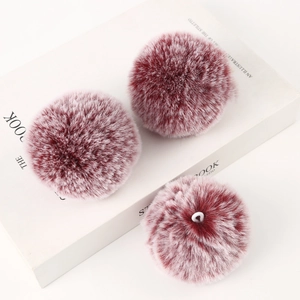 Three burgundy faux fur pom poms with elastic loops on a minimalist white background