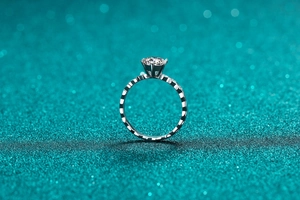 Macro shot of 925 sterling silver ring with six-prong moissanite setting and textured band
