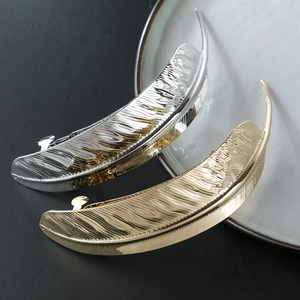 Polished metal leaf hair clips in gold and silver finish, elegant feather spring barrettes
