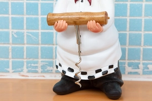 Detail of vintage chef wine opener with resin figure, wooden handle and metal spiral