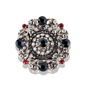 Vintage Baroque hollow badge brooch with black center stone and crystal accents on white background