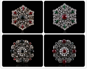 Detail of vintage baroque mandala brooches with colorful crystals and hollowed alloy metal