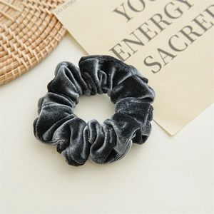Macro shot of grey velvet scrunchie showing glossy soft texture and rich fabric folds