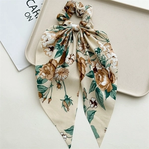 Detail of floral oversized scrunchie with long streamers in beige and rose pattern