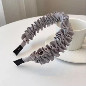 Detail showing the pleated gray fabric texture and black ends of the stylish headband