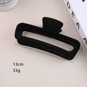 Detail of 13cm black flocked hair claw clip showing 33g weight and internal teeth texture