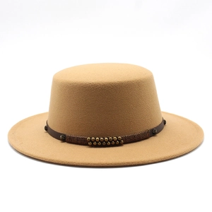 Détail d'un canotier en laine camel avec bande en cuir marron et rivets en bronze