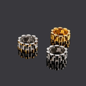 Three men's watch band style rings in silver and gold colors on reflective surface