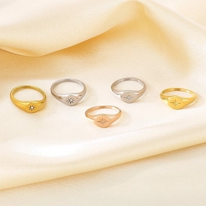 Detailed display of five 18K gold plated starburst rings on soft satin background