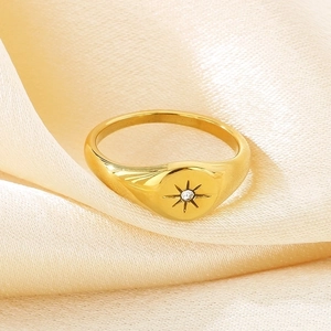 Detailed macro view of 18K gold plated stainless steel starburst ring on silk