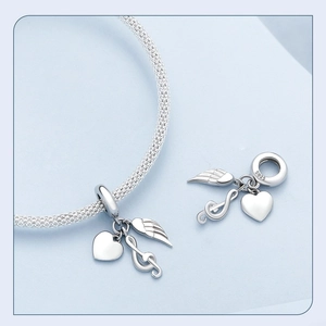 Macro detail of S925 sterling silver charms featuring heart, musical note and wing motifs