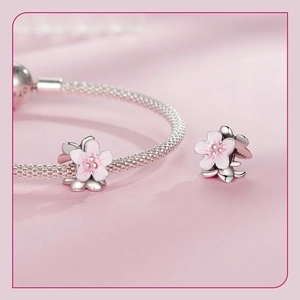 Macro shot of S925 sterling silver cherry blossom charm with pink enamel detail