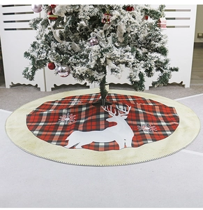 Top view of red and black plaid Christmas tree skirt with reindeer and snowflake print