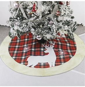 Detail of red and black buffalo plaid Christmas tree skirt with reindeer and snowflake patterns