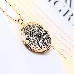 Close-up of golden round locket pendant with floral relief on vintage paper background