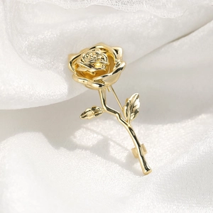 Elegant gold-plated rose brooch pin for suits on white silk background