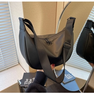 Detail view of the black Oxford dumpling bag with dual metal zippers and wide fabric strap