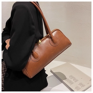 Detailed side view of a brown vintage Boston bag showing its size and premium texture