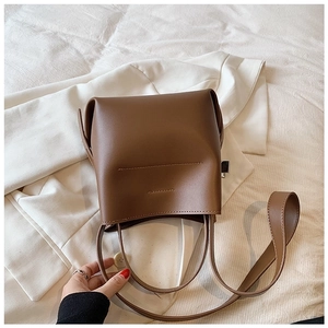 Detail showing high-quality brown leather texture and stitching of the bucket bag