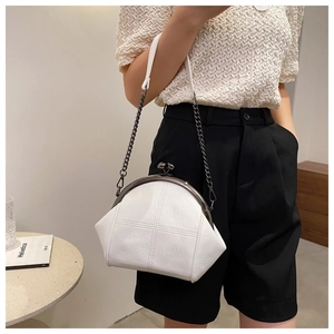 Detail of white leather frame bag featuring cross-stitch texture and gold chain strap
