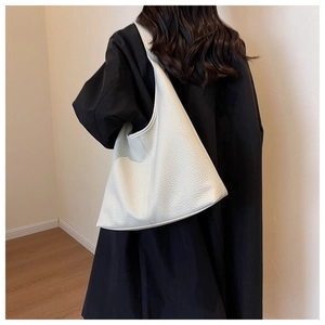 Detail of white lychee leather tote bag showing soft texture and spacious interior design