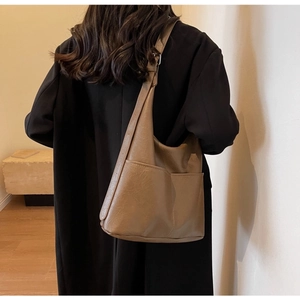 Close-up of the vintage brown PU leather texture and side pocket of the large bucket bag