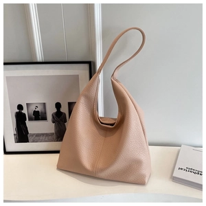 Macro detail of nude pink lychee textured leather tote bag in a minimalist setting