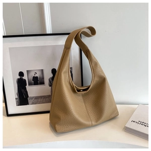 Detail of khaki lychee-pattern faux leather hobo bag in a minimalist lifestyle setting