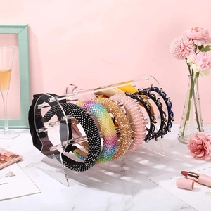 Pink acrylic headband display stand with cylindrical bar on marble surface