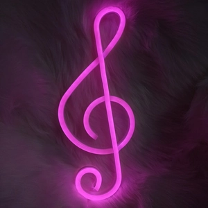 Pink LED neon light G-clef musical symbol on dark plush background for room decor