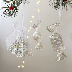 Iridescent acrylic Christmas ornaments in candy and bell shapes on a festive tree