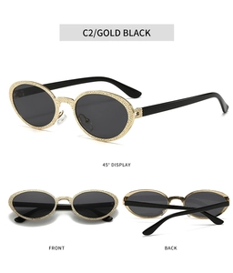 Detail view of oval metal sunglasses with textured gold frames and black lenses