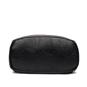 Bottom view of large black leather backpack showing durable stitching and soft texture